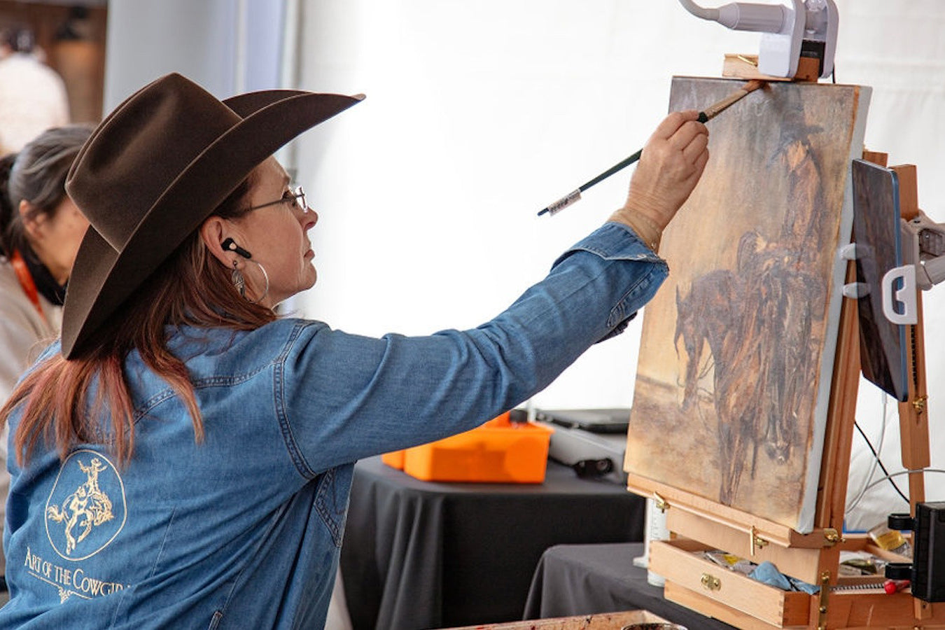 Art of the Cowgirl artist painting at the event.